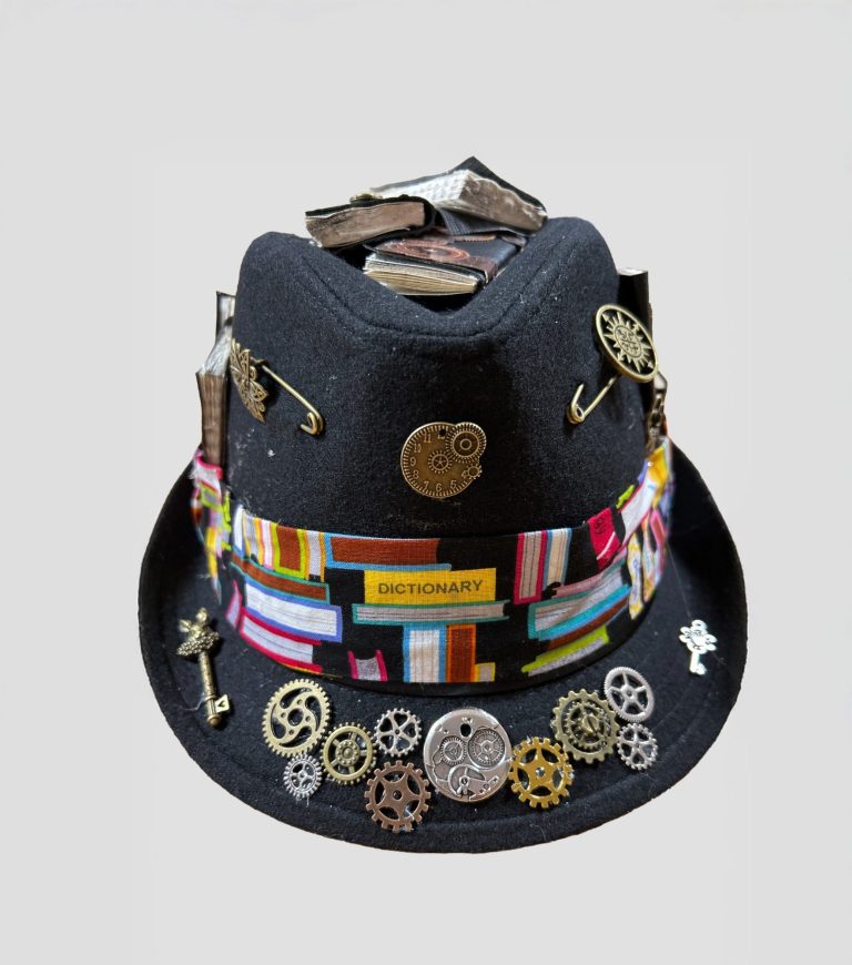 A brown bolo hat decorated in steampunk style with goggles and other steampunk themed items.