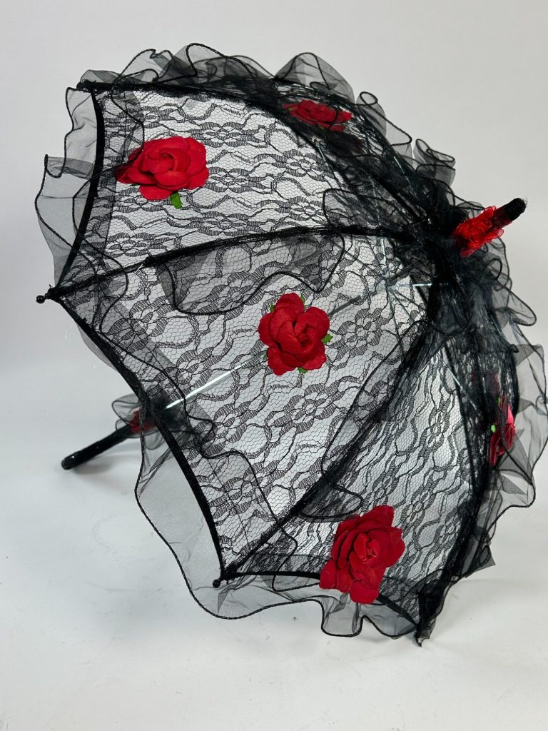 A black lace umbrella accented with red roses.