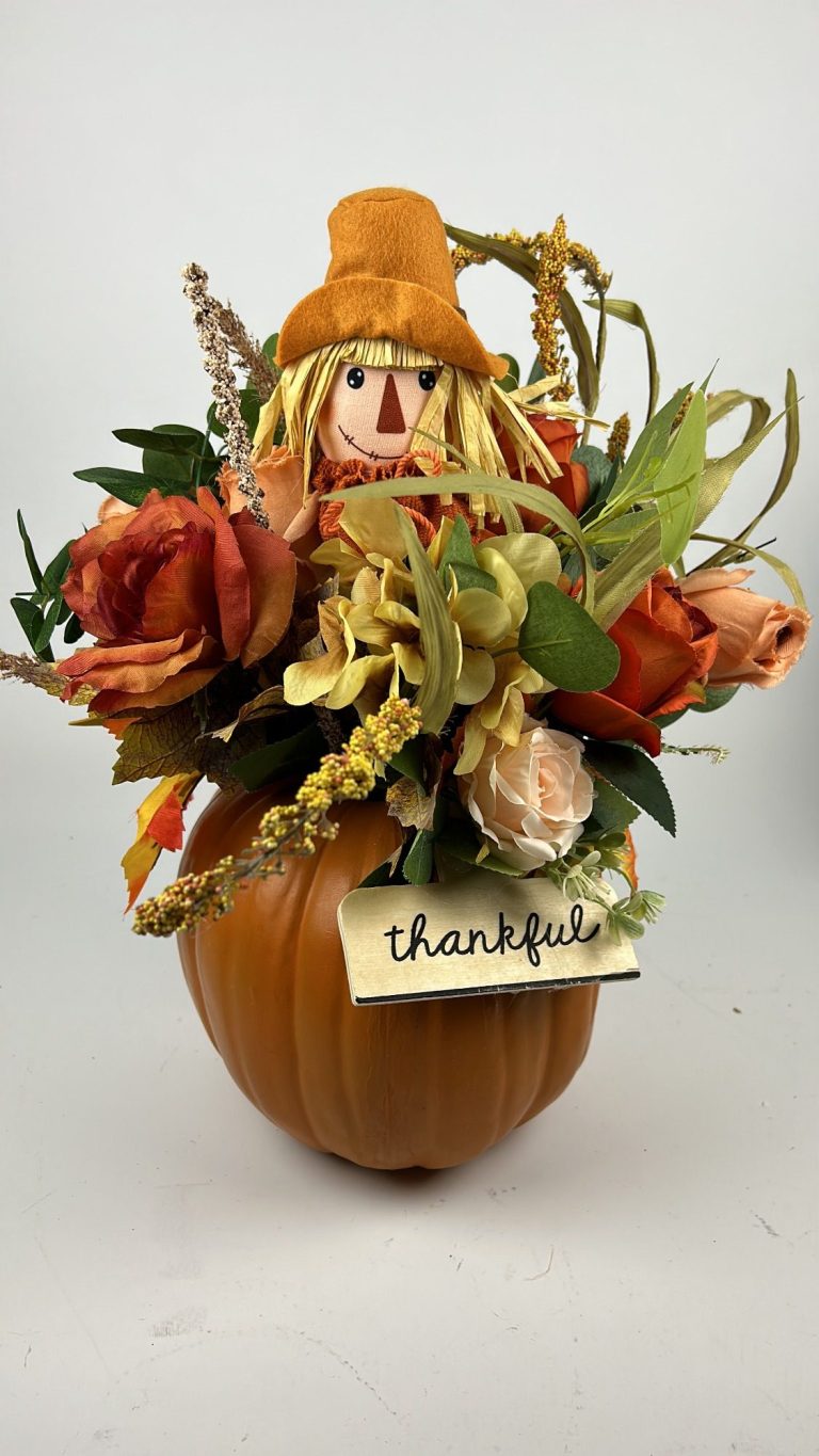 A fall colored centerpiece in a round vase.