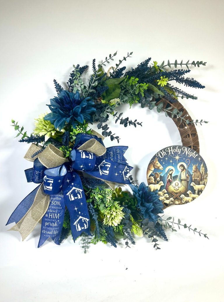 A grapevine wreath decorated with greenery and blue and white flowers.